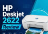 HP Deskjet 2622 Printer Review A compact white inkjet printer on a small home-office desk with a laptop beside it, soft natural window light
